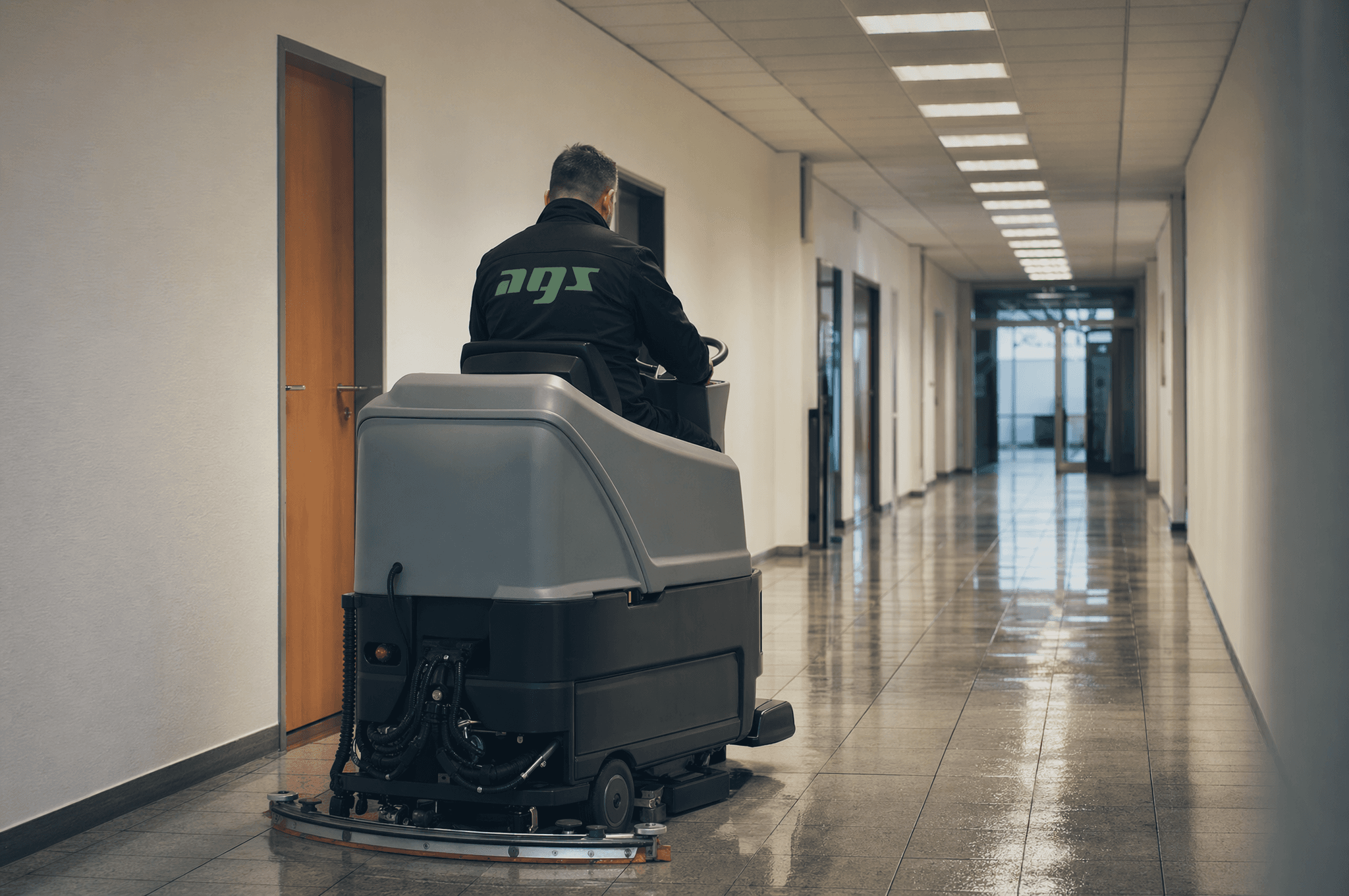 Maschinelle Grundreinigung eines Gebäudeflurs mit einer Aufsitz-Scheuersaugmaschine von AGS