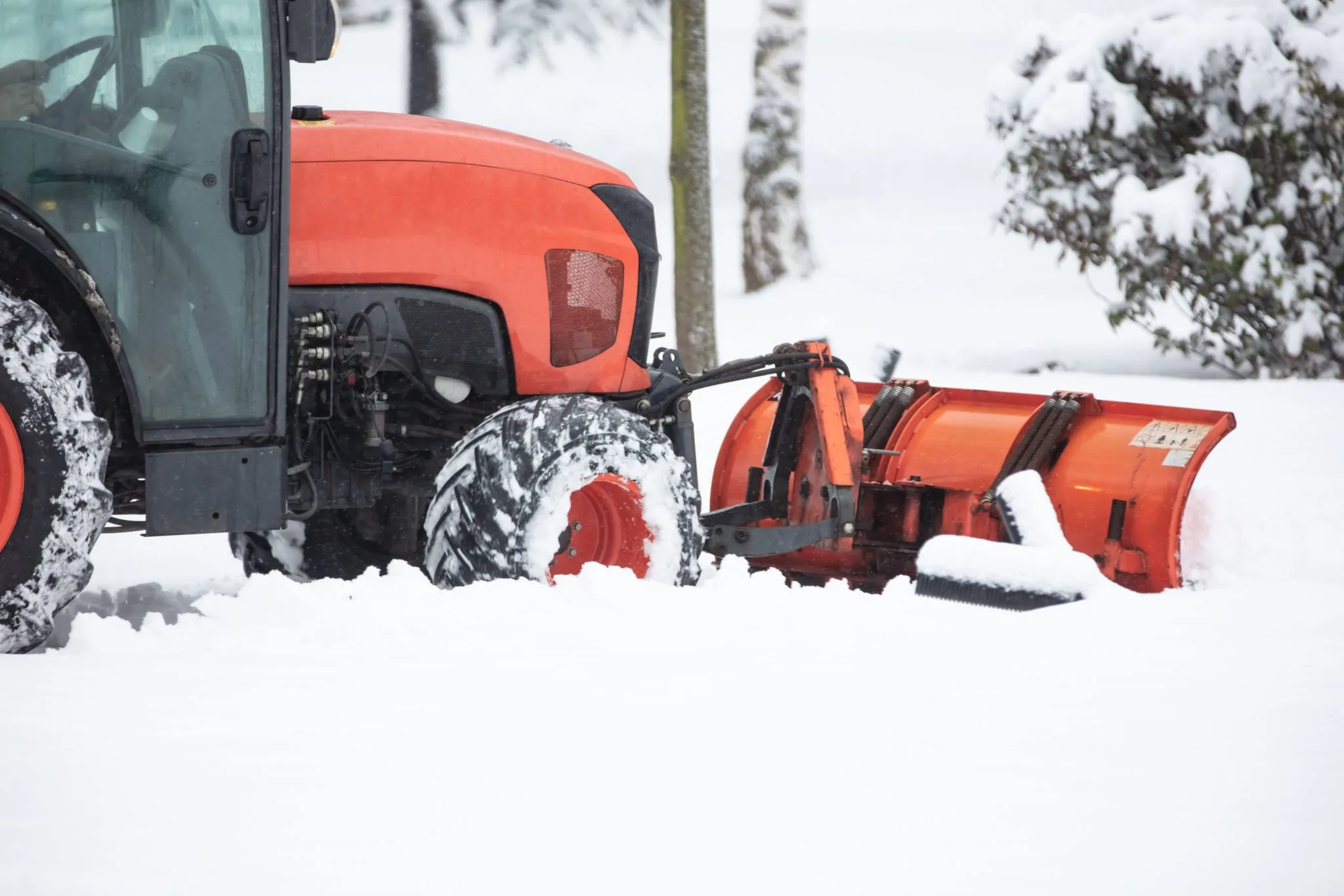 Traktor mit Räumschild beim Schneeräumen