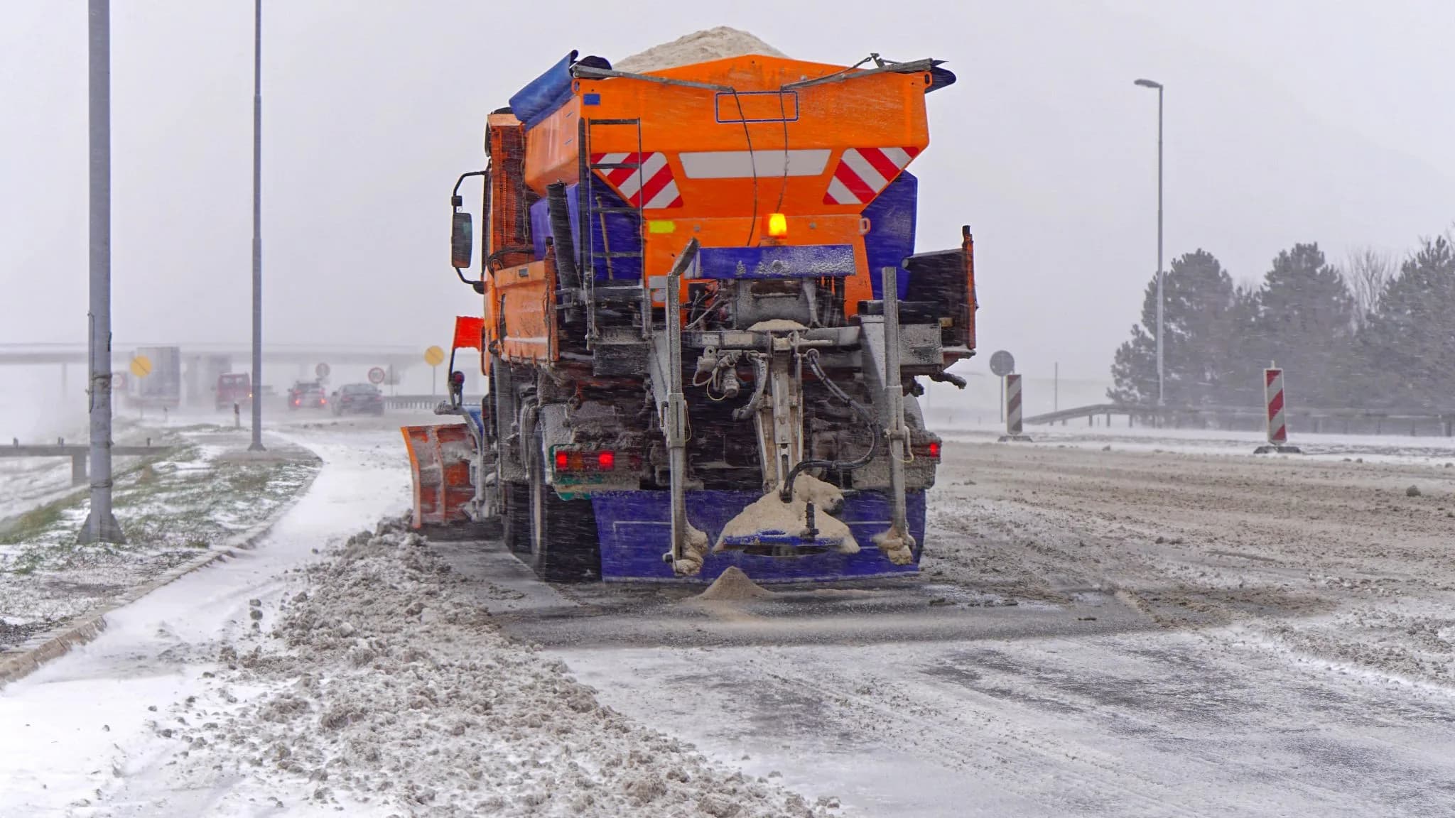 Streufahrzeug beim Räumen und Streuen einer Zufahrt
