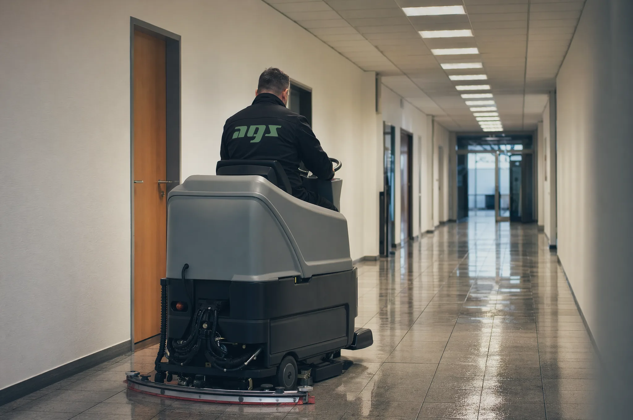 AGS-Mitarbeiter bei der maschinellen Bodenreinigung eines Büroflurs