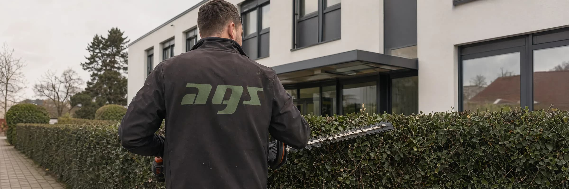 Heckenschnitt vor einem Bürogebäude – Grünpflege durch AGS Facility Services
